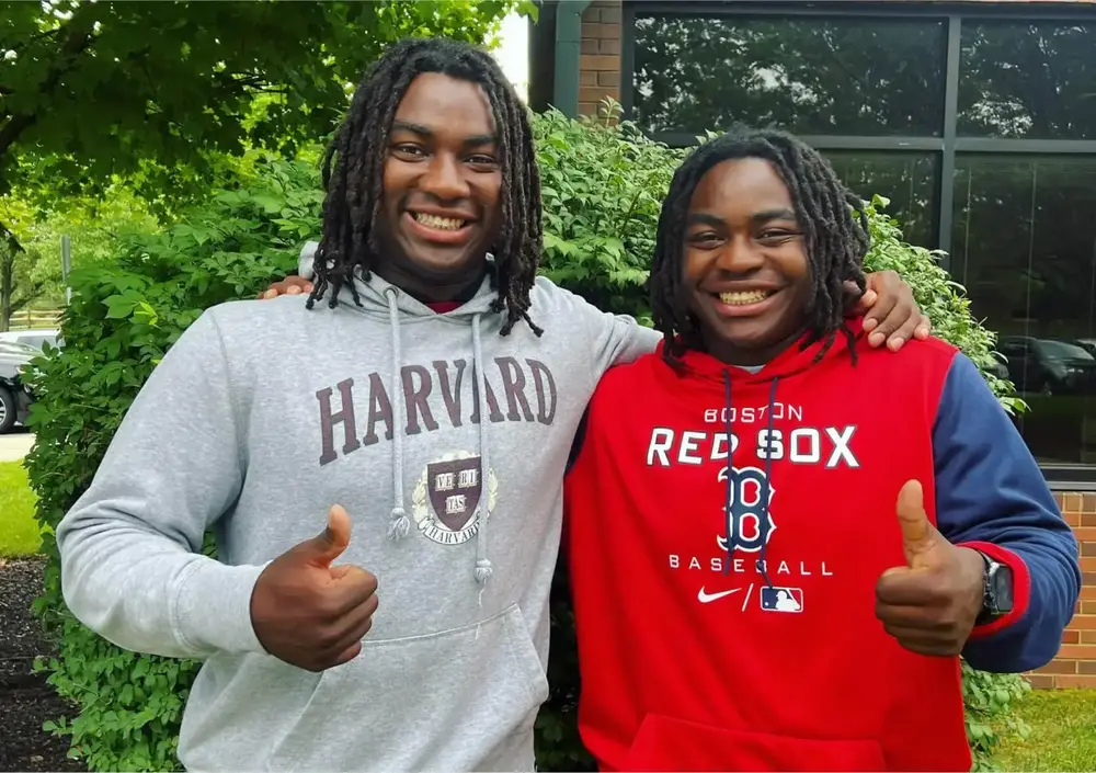 Two young men giving thumbs up to the camera