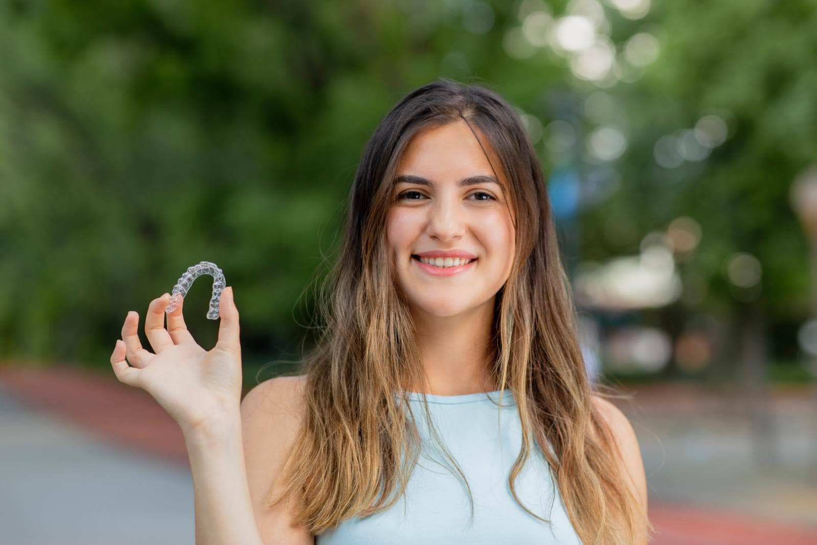 Woman holding Invisalign aligner