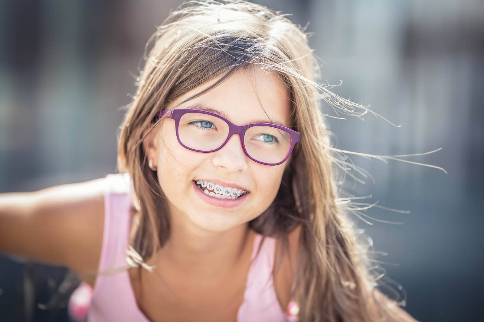 Portrait of happy smiling girl with dental braces and glasses.